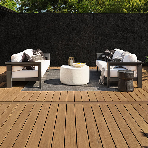 Brownish grey furniture on the medium brown coconut husk decking and a dark foliage in the background.