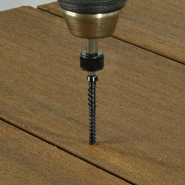 Piattaforma sopra calcestruzzo con il trapano ed il fermo sul bordo composito di decking