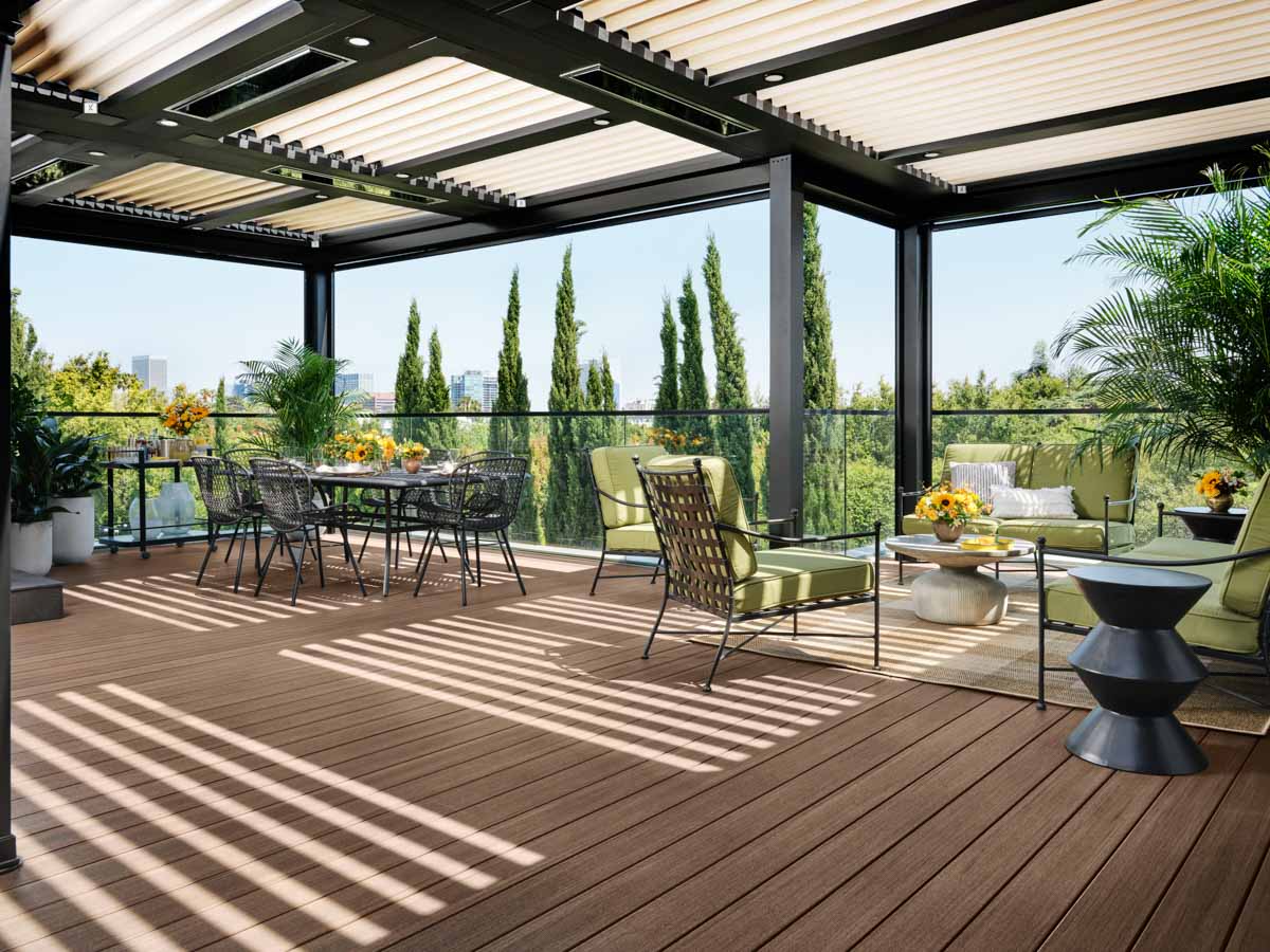 Drew's deck has two seating areas, large potted plants, and a pergola overhead