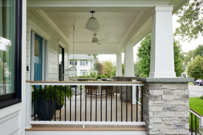High contrast TimberTech white railing with black balusters and light brown porch