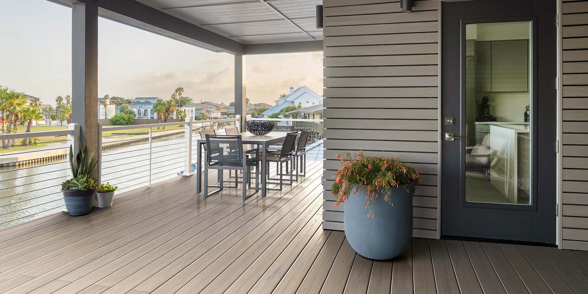 White Impression Rail Express railing with horizontal cable rail infill on a waterfront home's deck