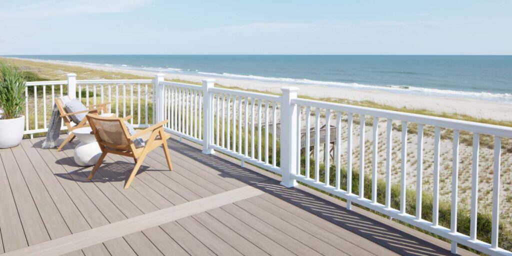 Two chairs on a deck on the beach with a RadianceRail Express in White railing