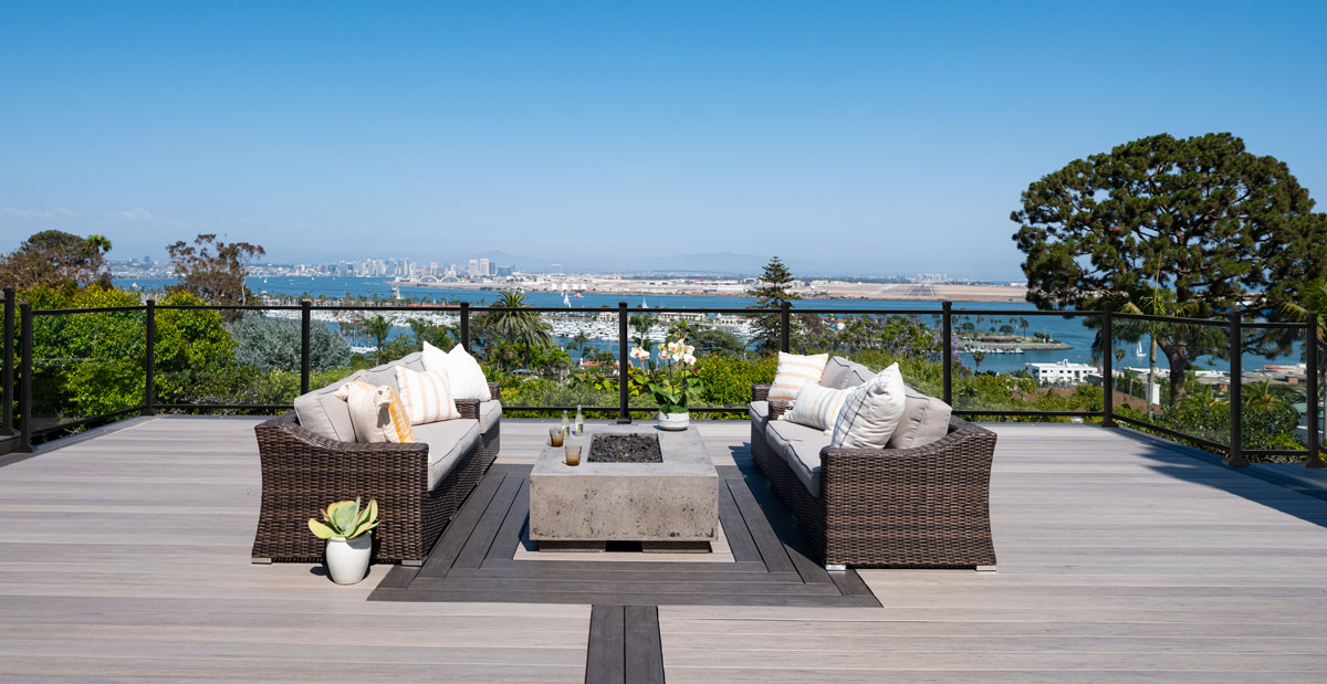 Waterfront property on the bay of an urban area with two couches facing each other on a multi-tonal TimberTech deck